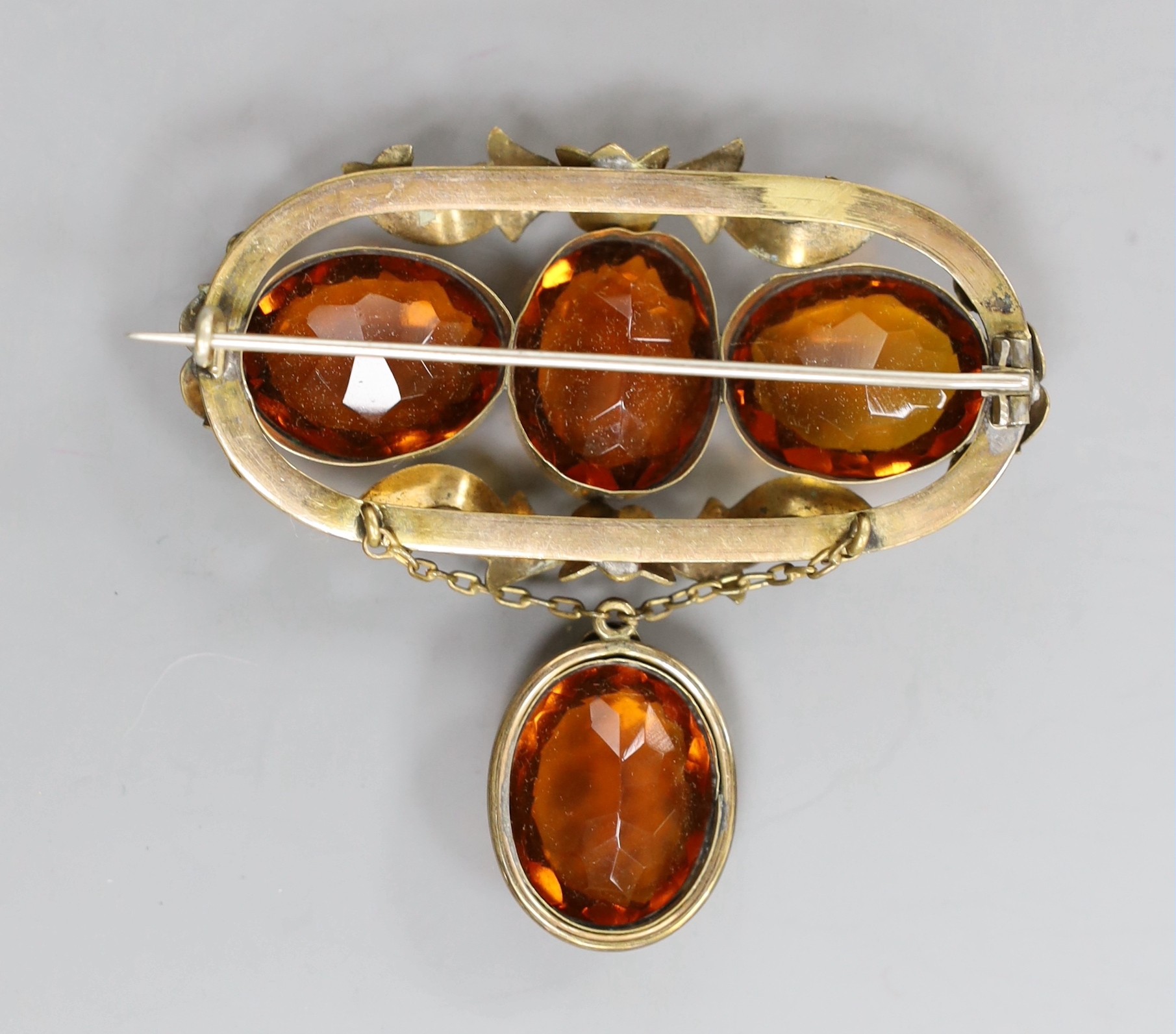 A Victorian pinchbeck and four stone oval cut citrine set drop brooch, width 64mm.